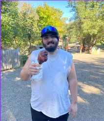 A member of the Lead On group, Xander, enjoying a giant turkey leg at Vala's Pumpkin Patch during their fall outing.