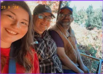 Three members of the Lead On group smiling on a scenic ride at Vala's Pumpkin Patch during their fall outing.