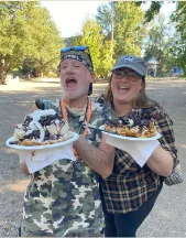 Two members of the Lead On group happily showing off their delicious funnel cakes at Vala's Pumpkin Patch during their fall outing.