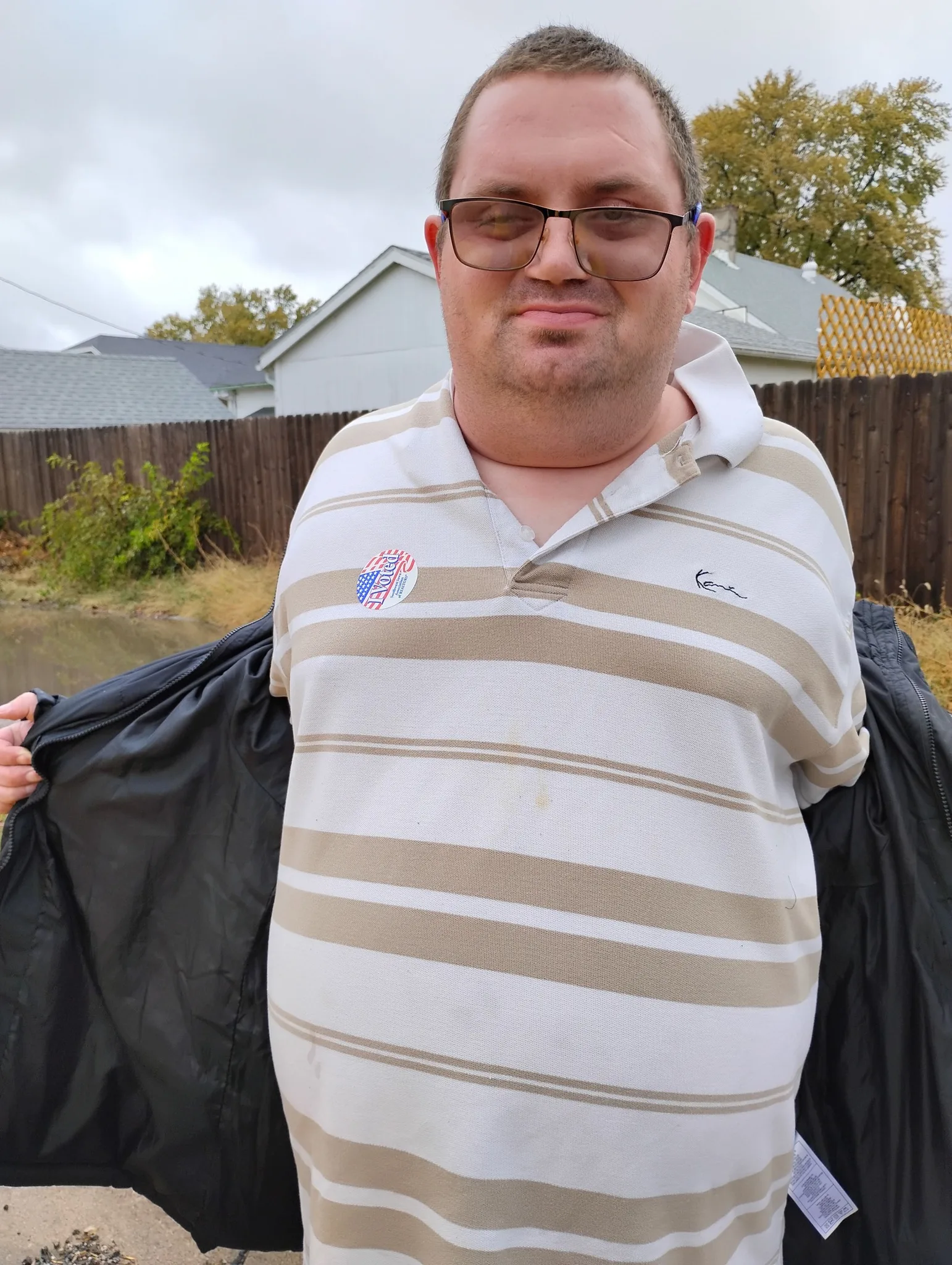 Travis proudly displays his "I Voted" sticker while standing outdoors after casting his ballot in the election.