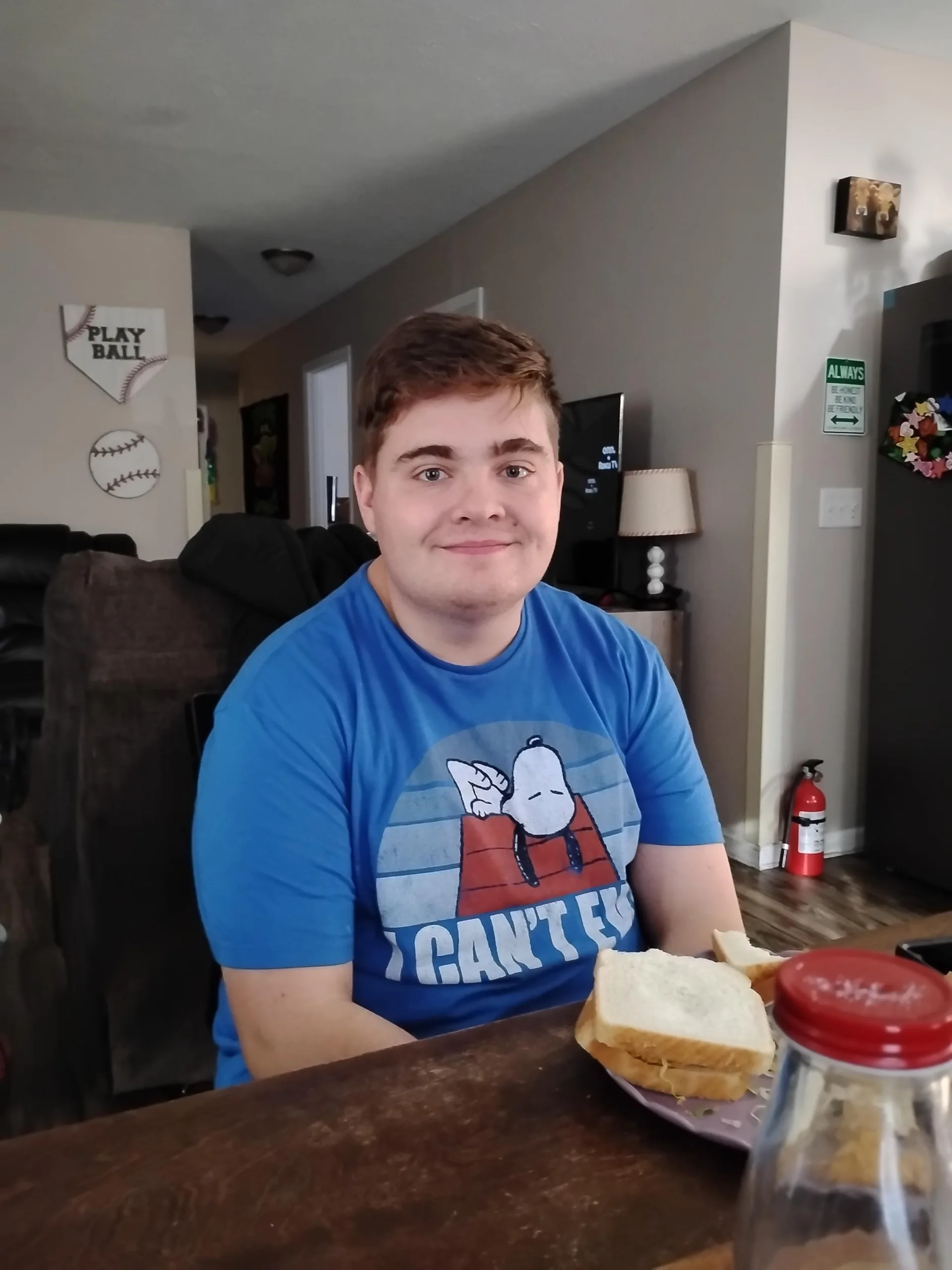 Aaron sitting at a dining table, smiling while enjoying a meal at his AmeriServe residential home.